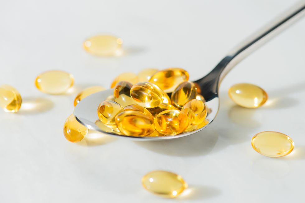 food supplement omega 3 in a spoon, medical supplements and vitamins d