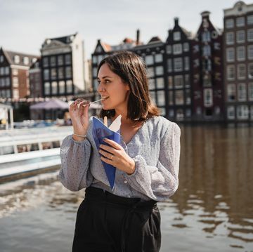 jonge vrouw eet friet in amsterdam