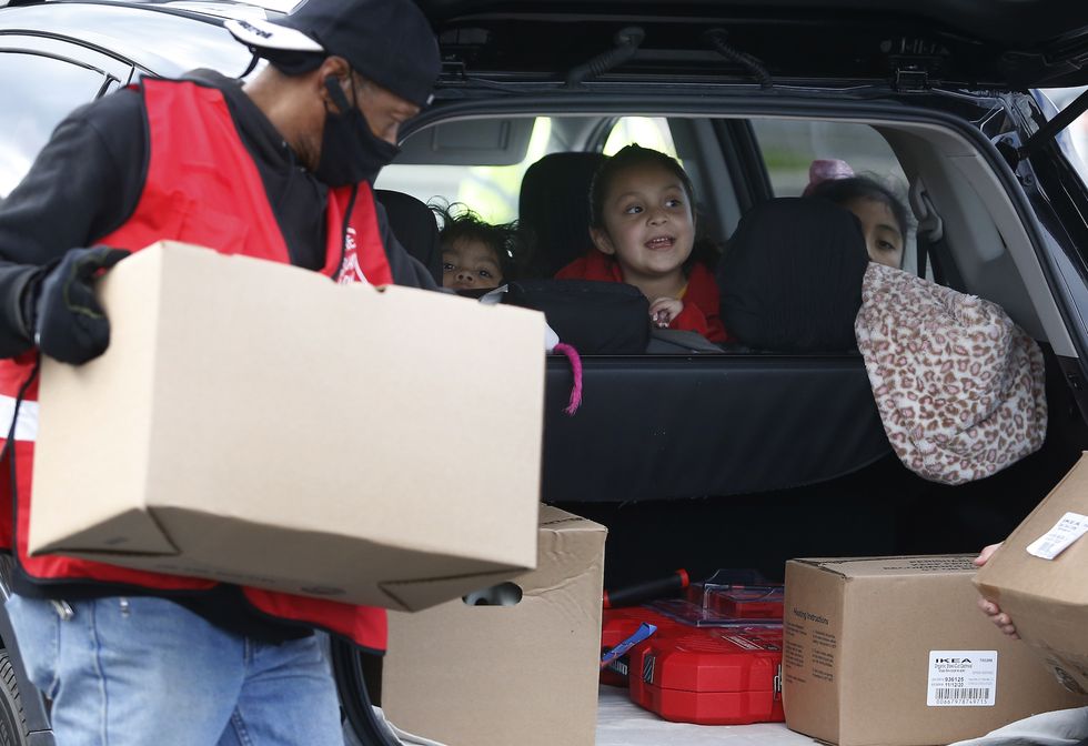 lynn, ma   november 16 children look back at santa while food is delivered to their car as santa visits the salvation army's food pantry at manning field in lynn, ma to spread a little holiday cheer on nov 16, 2020 before the covid 19 pandemic, the food pantry served an average of 60 families a day that number has increased to over 600 families daily as more residents face financial hardship and food insecurity photo by jessica rinaldithe boston globe via getty images