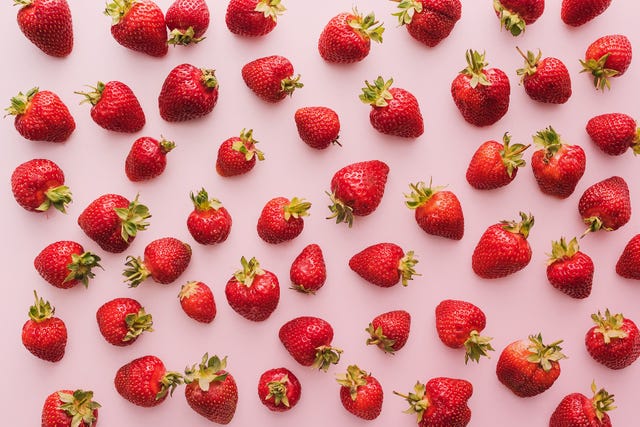 top view of whole and red strawberries on white background