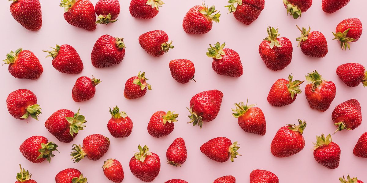 top view of whole and red strawberries on white background