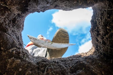 foot digging an earth in the garden with an old spade, close up