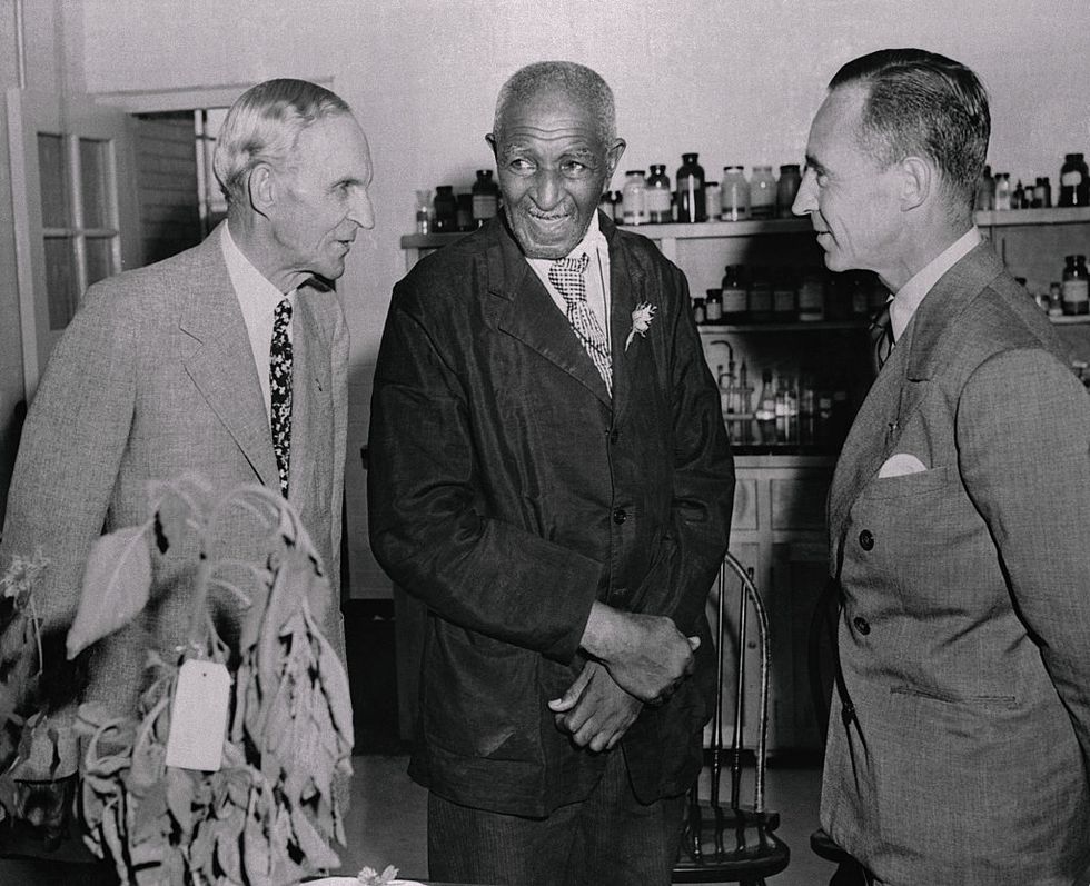 henry and edsel ford talking on either side with george washington carver and all of them smiling