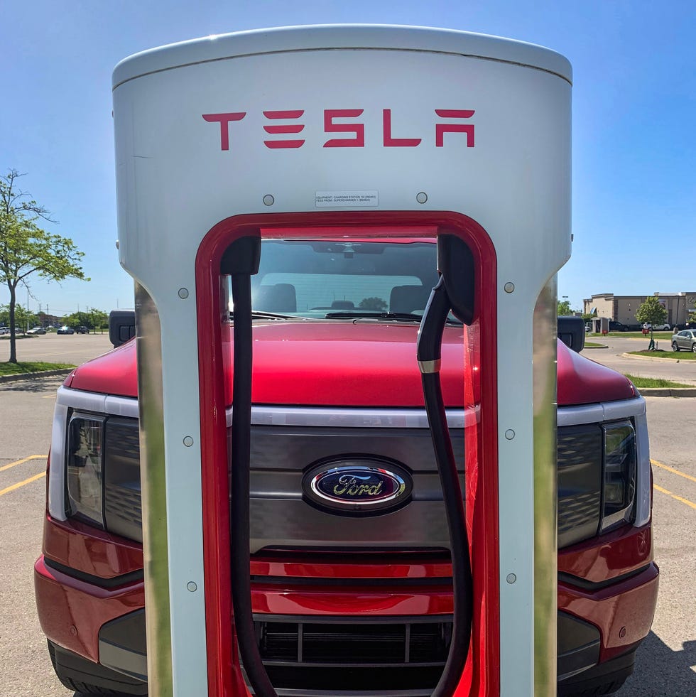 a ford f 150 lightning at a tesla charging station