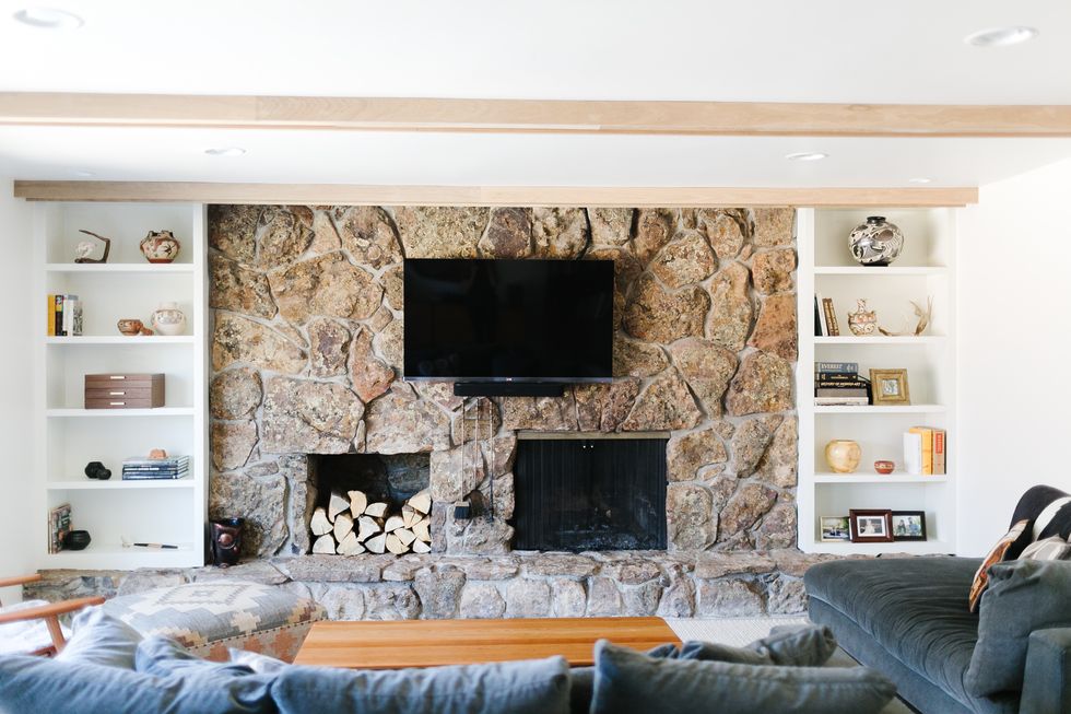 large stone fireplace with mounted tv