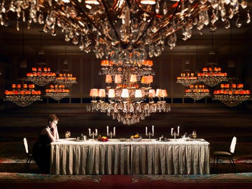 woman sitting at a table set with candles that could potentially spill wax on surrounding carpet