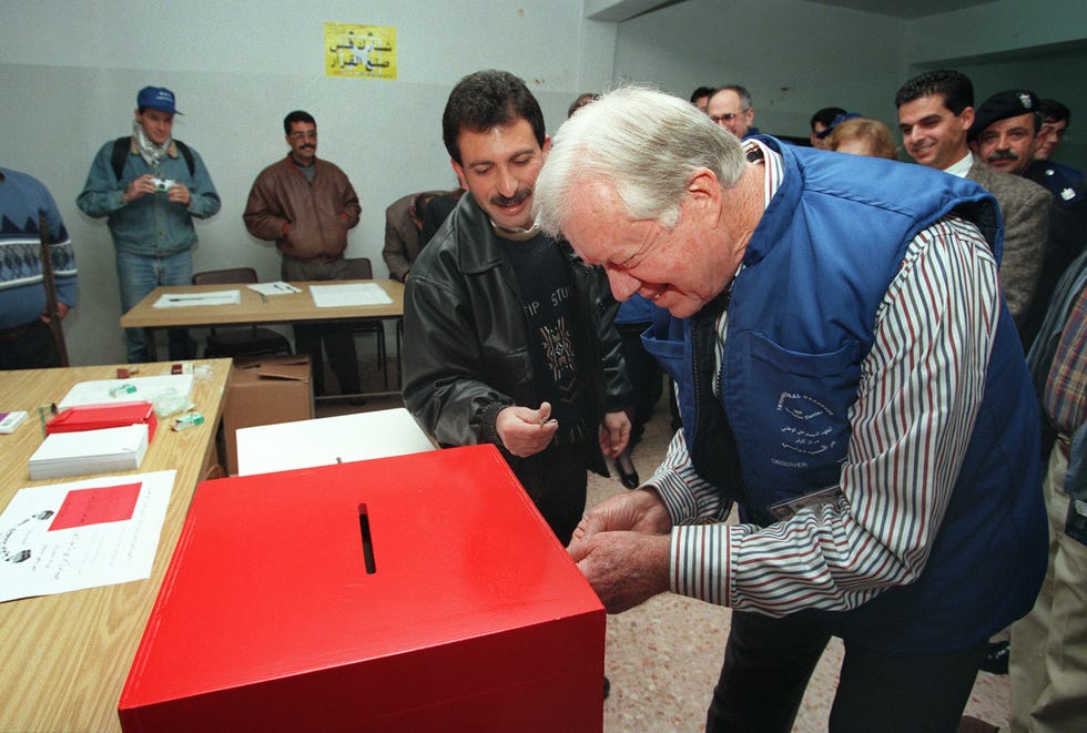 jimmy carter checks a ballot box in the daheisha refugee camp in the west bank 20 january 1996, carter was heading an international delegation to observe the palestinian elections