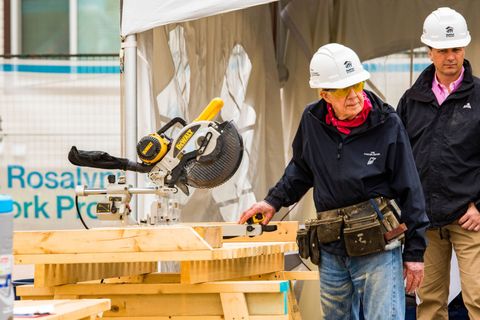 former us president jimmy carter standing next to a power saw during a community project