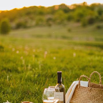 a picnic basket with food and wine bottle on it