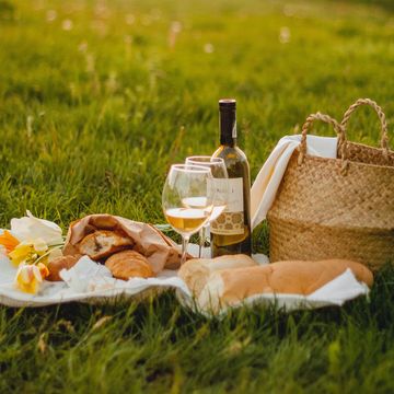 a picnic basket with food and wine bottle on it