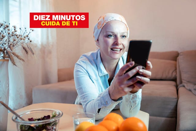 happy woman with headscarf in her living room using phone close up portrait