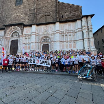 a group of runners standing in front of a historical building holding a banner a group of runners standing in front of a historical building holding a banner