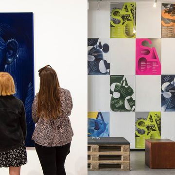 two women looking at a wall of art