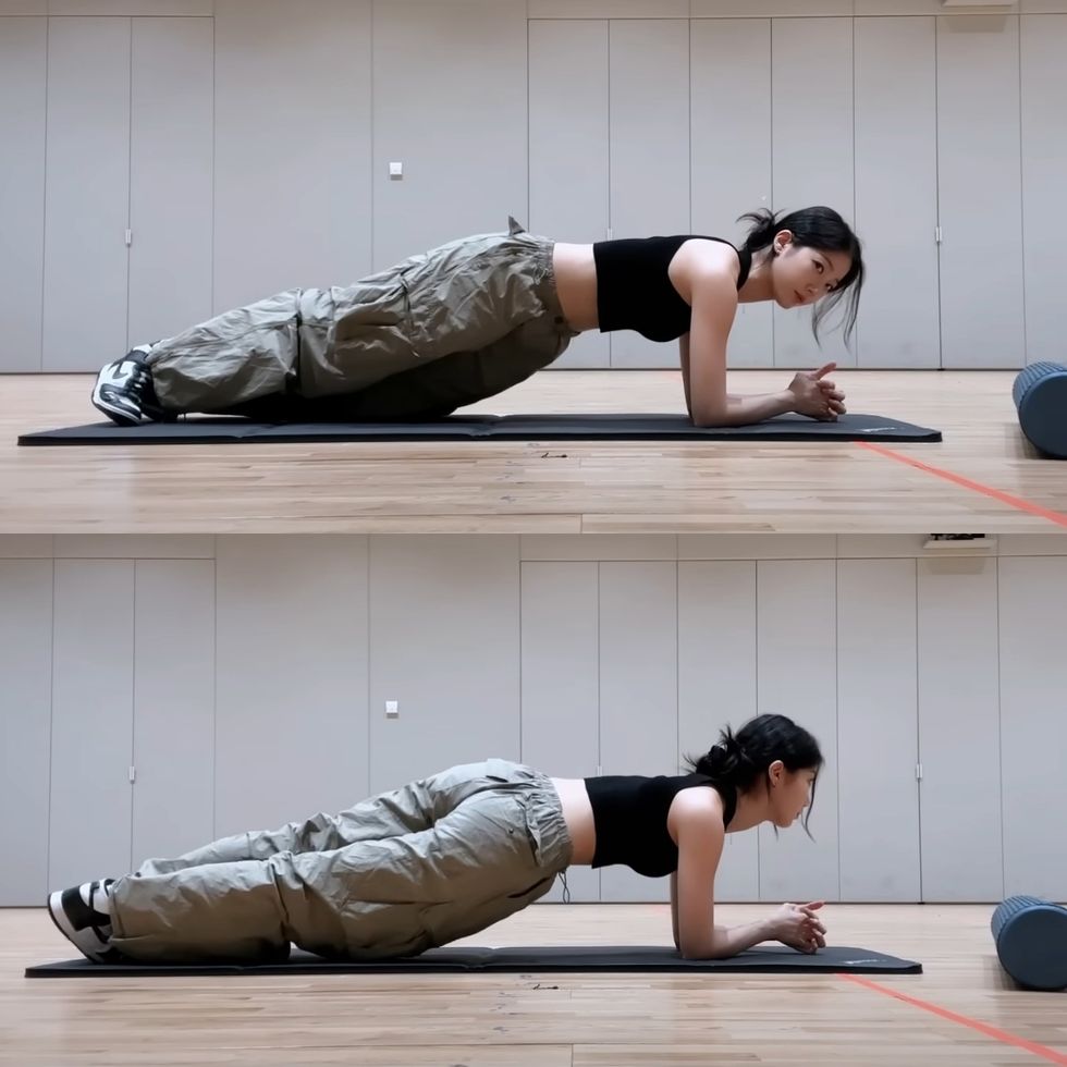 a person doing a plank on a mat with another woman in the background