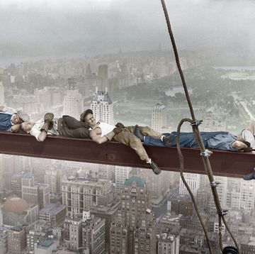 construction workers resting on steel beam above manhattan
