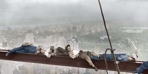 construction workers resting on steel beam above manhattan