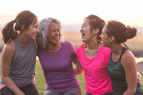 Four ethnic women laughing together after an outdoor workout