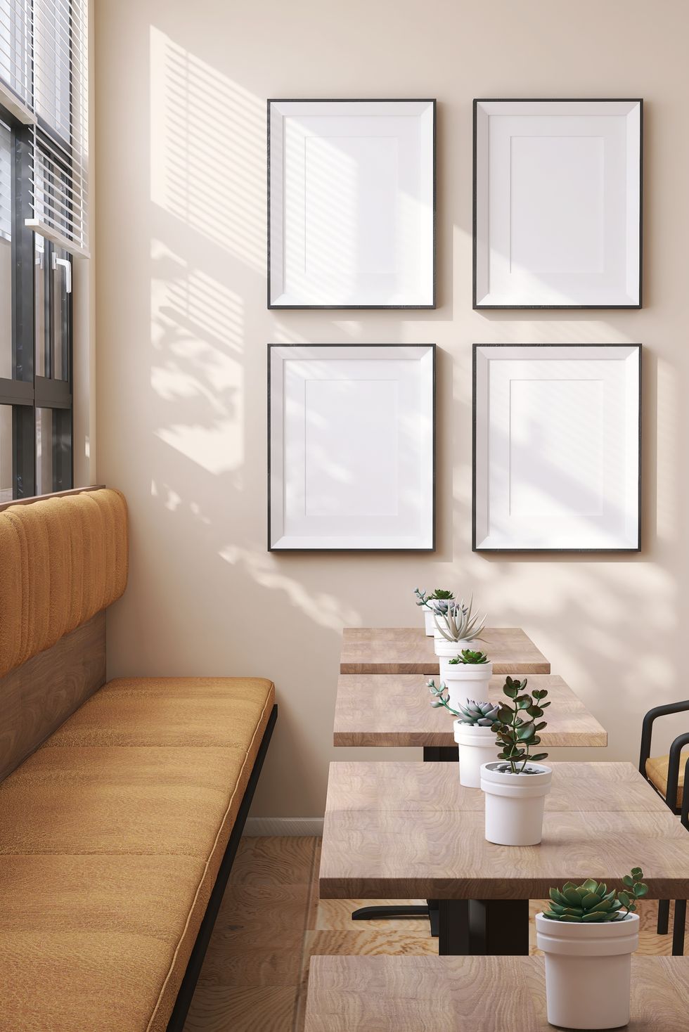 four large blank wooden picture frame with mat on cream colored wall in modern, luxury cafe restaurant in hotel with chair, table and potted plant