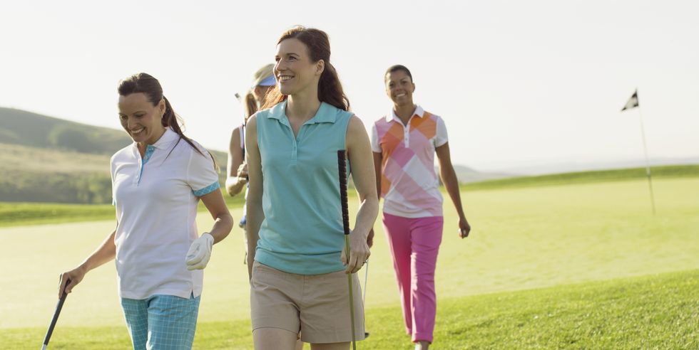 foursome of female golfers walking off green
