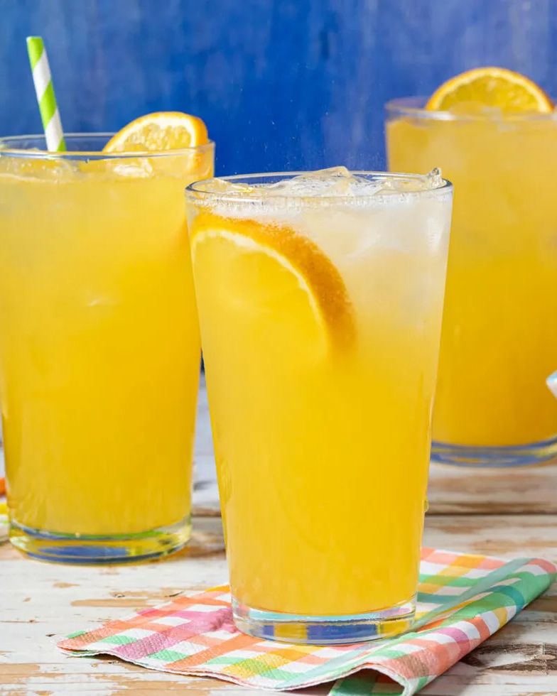 orange crush cocktail with orange slices blue background