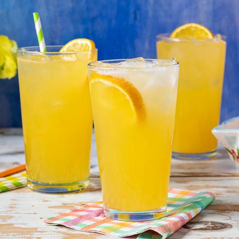 orange crush cocktail with orange slices blue background