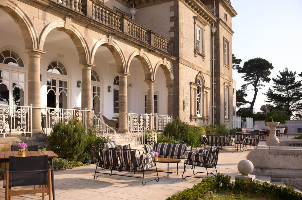 a patio with tables and chairs outside a building