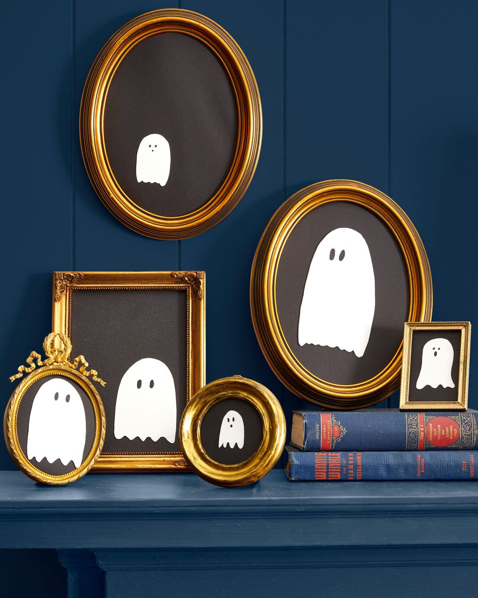 a grouping of simple white ghosts shapes on black paper inside gold colored frames a grouping of simple white ghosts shapes on black paper inside gold colored frames