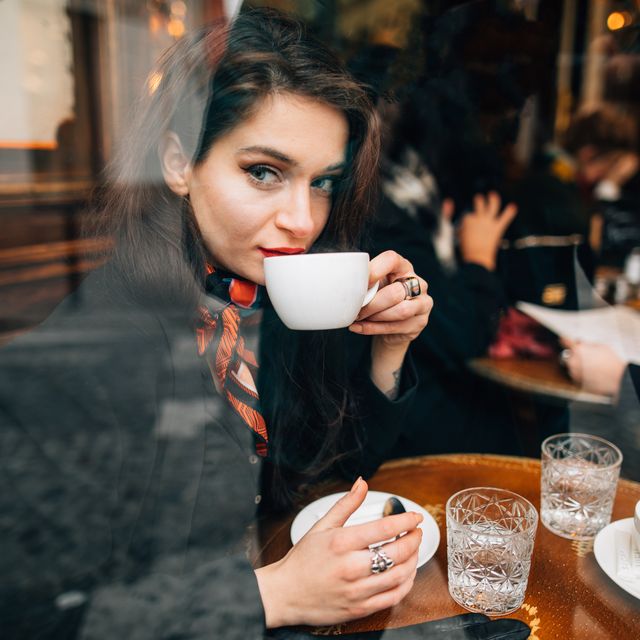woman drinking coffee in cafe in paris, france
