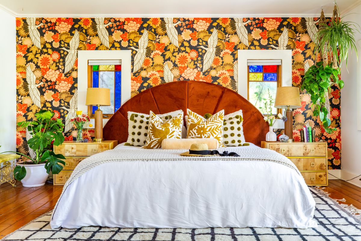 bedroom with velvet headboard and wallpaper with birds and flowers