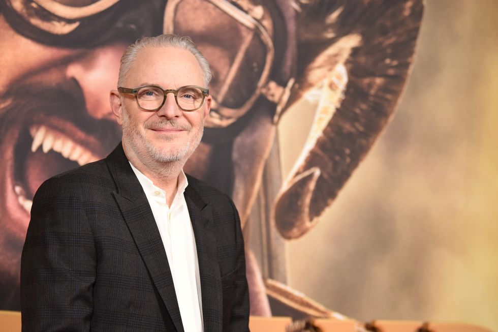 Francis Lawrence, un cineasta de pelo gris con gafas de color marrón claro, sonriendo a la cámara