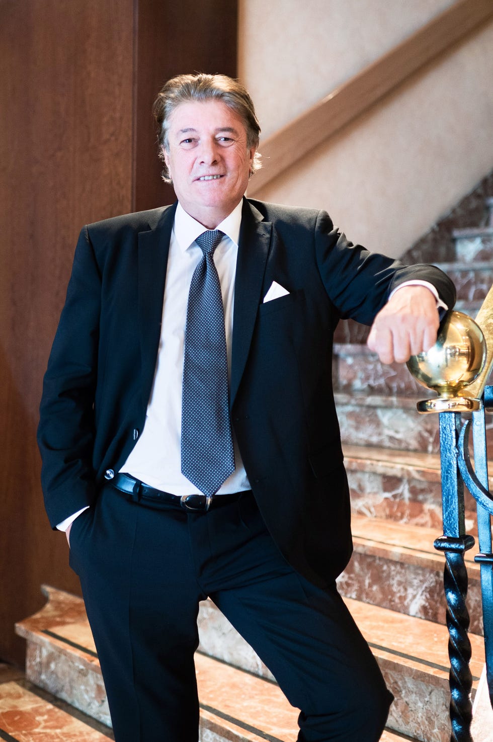 el cantante muy elegante posa ante unas escaleras
