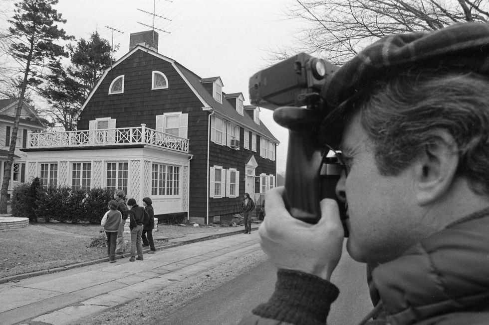 photographer taking photo of onlookers at amityville horror house on long island