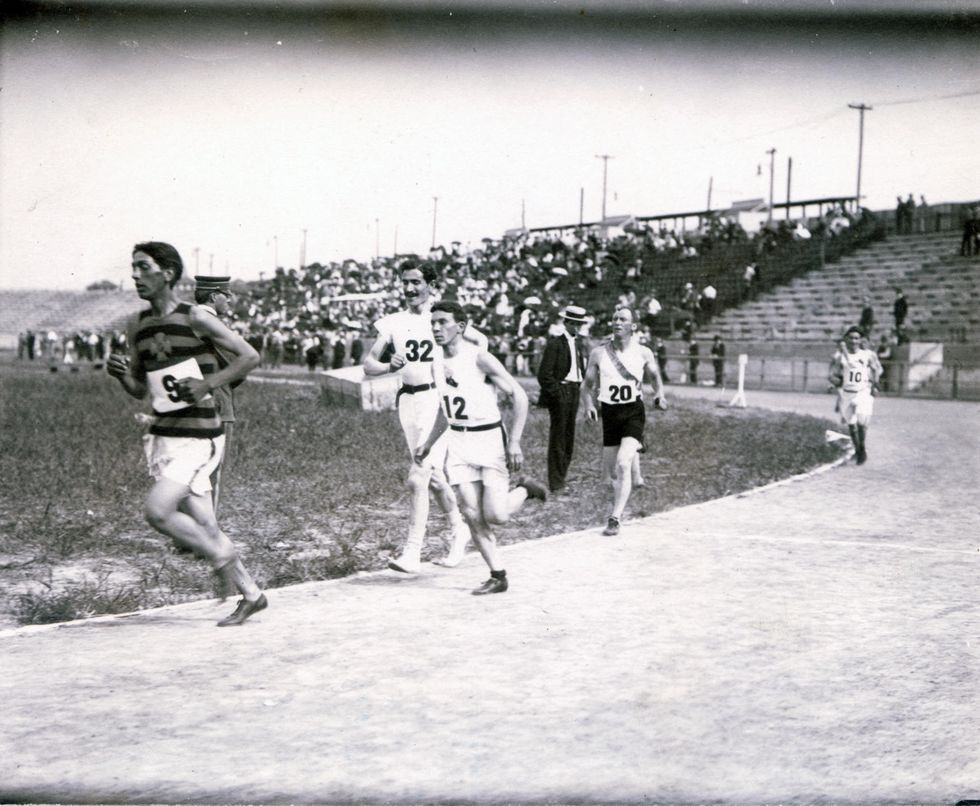 runners circling the stadium track for the first time during the marathon race in the 1904 olympics during louisiana purchase exposition