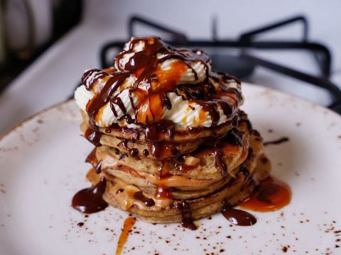 stack of frappuccino pancakes topped with whipped cream, dalgona coffee, and melty chocolate and caramel