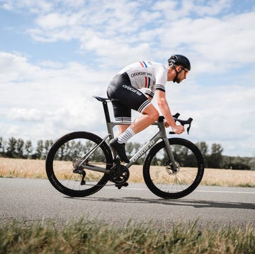 een wielrenner op een racefiets staand op de pedalen