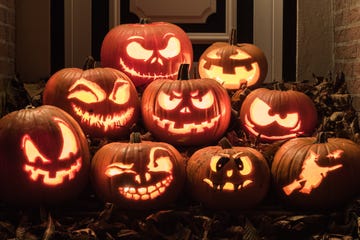 night shot of illuminated pumpkins in front of a house