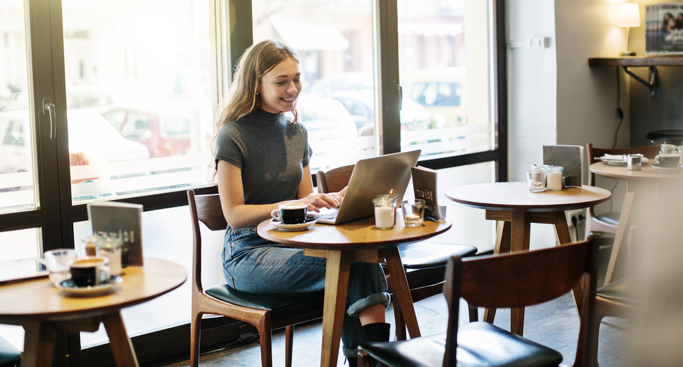 woman sat working in coffee shop