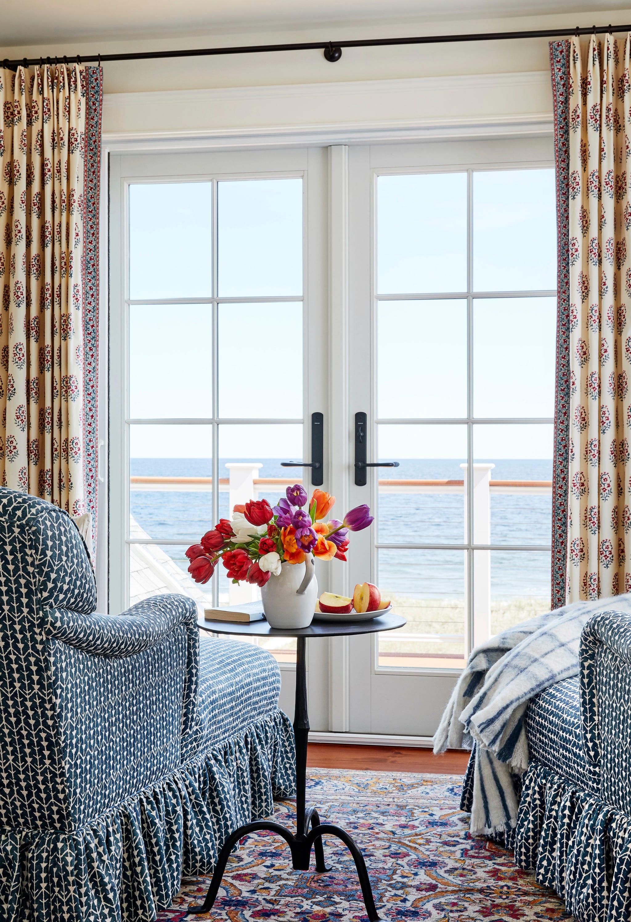 a pair of blue and white chairs in front of french doors