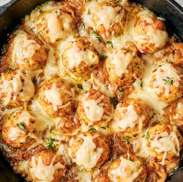 chicken meatballs in a skillet with onions and melty cheese