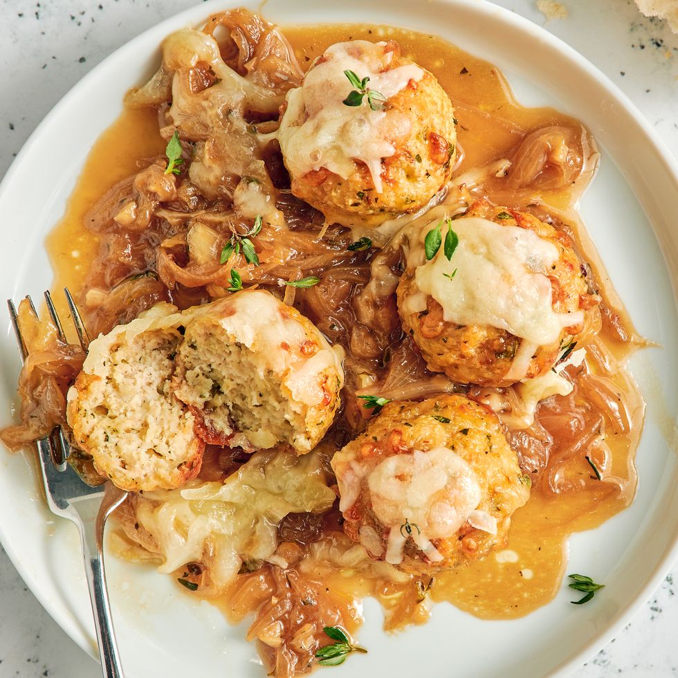 chicken meatballs in a skillet with onions and melty cheese