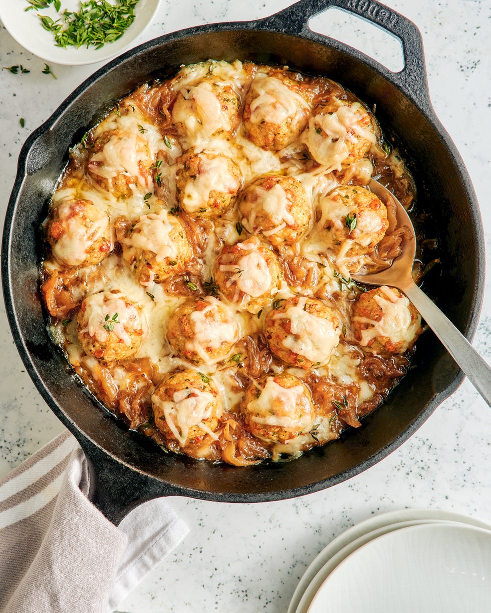 chicken meatballs in a skillet with onions and melty cheese