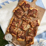 french onion flatbread on a wooden cutting board on a picnic blanket