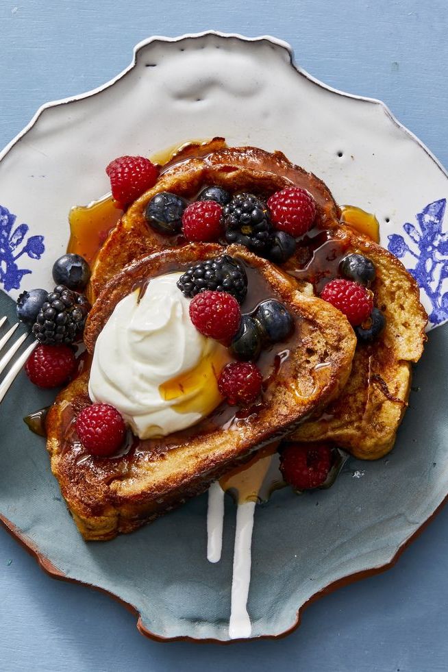 french toast with maple syrup, berries and whipped cream on top