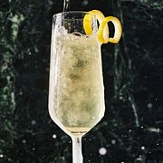 french 75 in a flute garnished with a lemon twist