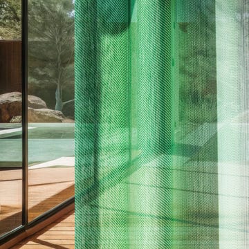 translucent green fabric curtain filtering light and revealing a view of the outdoors translucent green fabric curtain filtering light and revealing a view of the outdoors