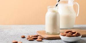 fresh almond milk in glass bottle and jug healthy vegan eating lack of cholesterol