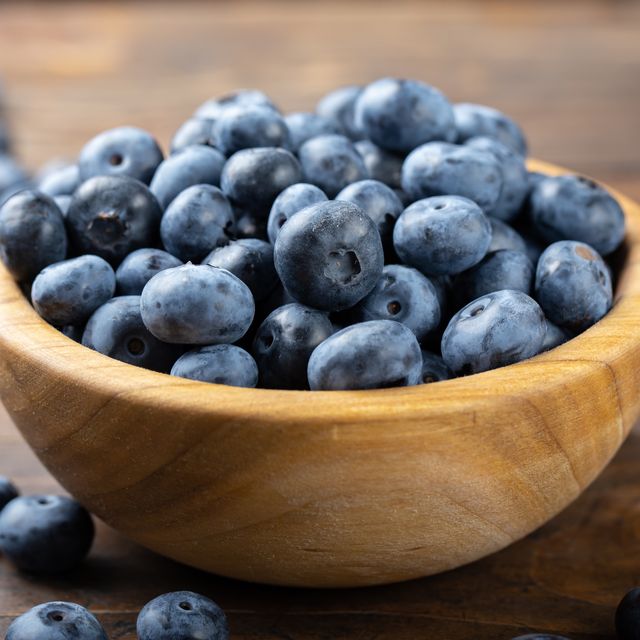 fresh blueberry in wooden bowl. concept of healthy and dieting eating.