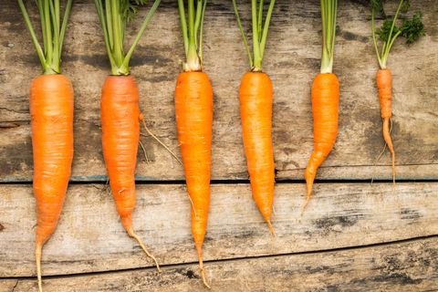 fresh carrots lying on wooden background