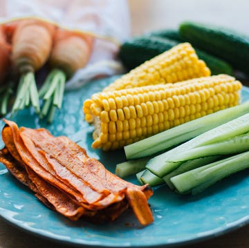 Fresh Cooked Carrot Bacon Lies On A Turquoise Plate With Corn And Cucumber. Meat Replacement, Snack fresh cooked carrot bacon lies on a turquoise plate with corn and cucumber meat replacement, snack