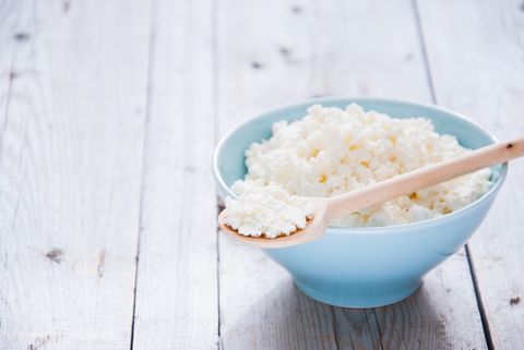 cottage cheese in a bowl bowl with wooden spoon